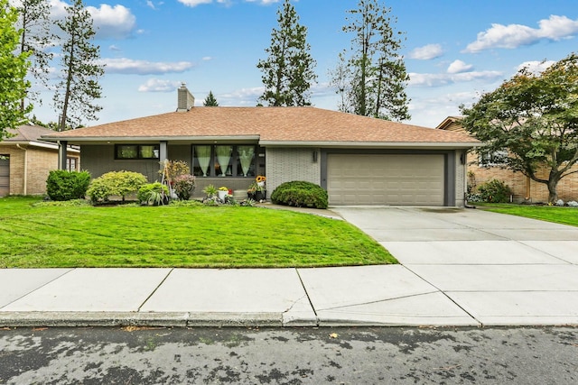 view of front of house featuring brick siding, a chimney, concrete driveway, an attached garage, and a front yard