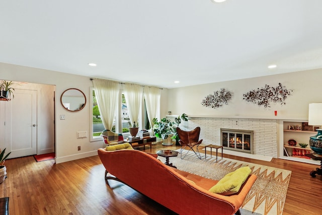 living room with recessed lighting, a fireplace, baseboards, and wood finished floors