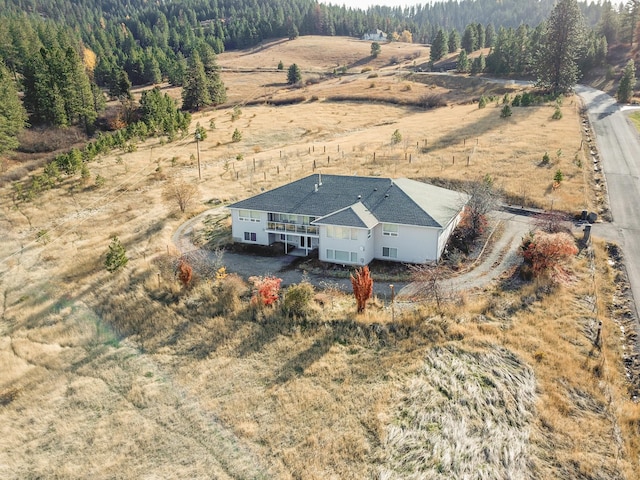 birds eye view of property featuring a wooded view and a rural view