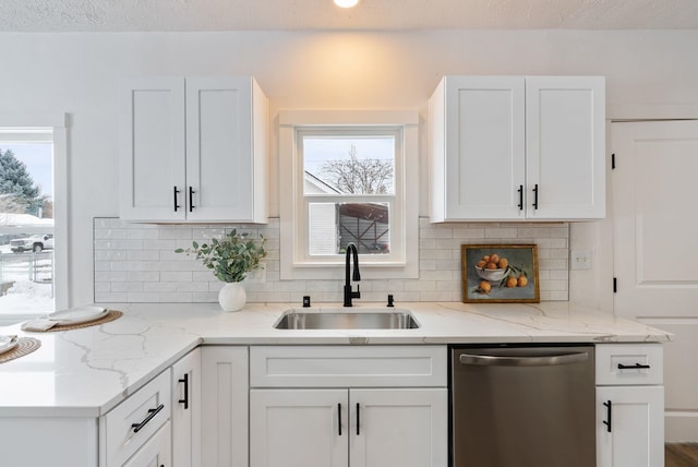 kitchen featuring a sink, white cabinetry, light stone counters, and dishwasher