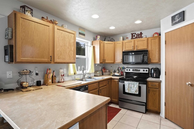 kitchen with light tile patterned floors, light countertops, appliances with stainless steel finishes, a sink, and a textured ceiling