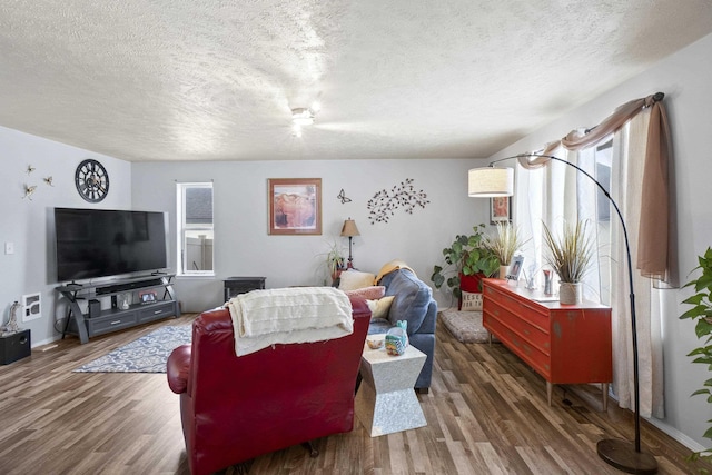 living area with dark wood-style floors, baseboards, and a textured ceiling