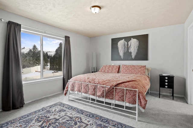 carpeted bedroom with a textured ceiling and baseboards