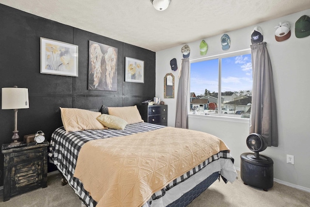 bedroom with a textured ceiling, carpet floors, and baseboards