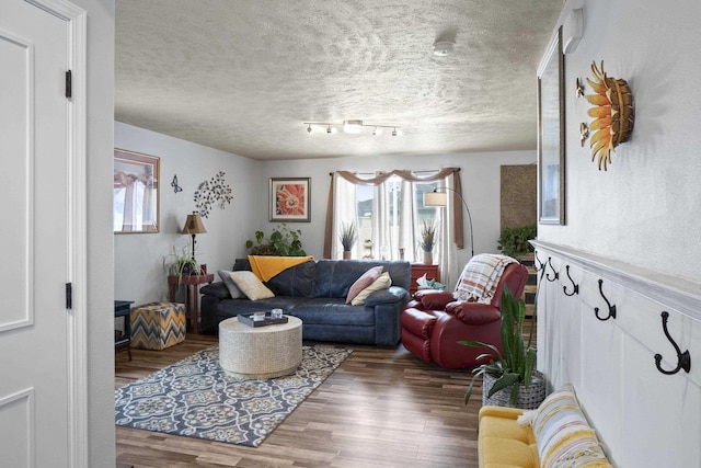 living room with a textured ceiling and wood finished floors