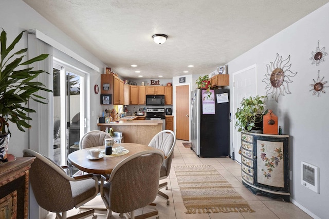 dining area with heating unit, light tile patterned floors, visible vents, a textured ceiling, and baseboards