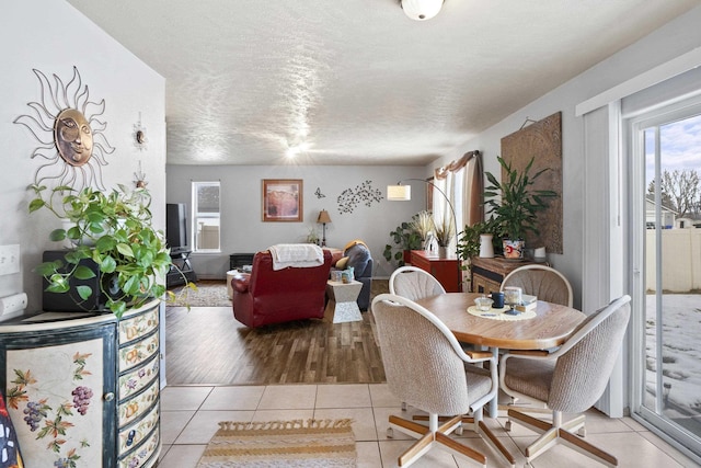 dining space with light tile patterned floors and a textured ceiling