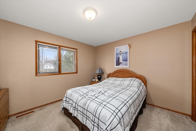 bedroom featuring light carpet and baseboards