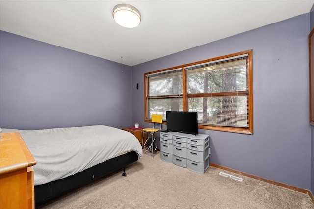 bedroom with visible vents, light colored carpet, and baseboards