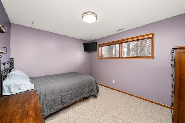 bedroom with baseboards, visible vents, and light colored carpet