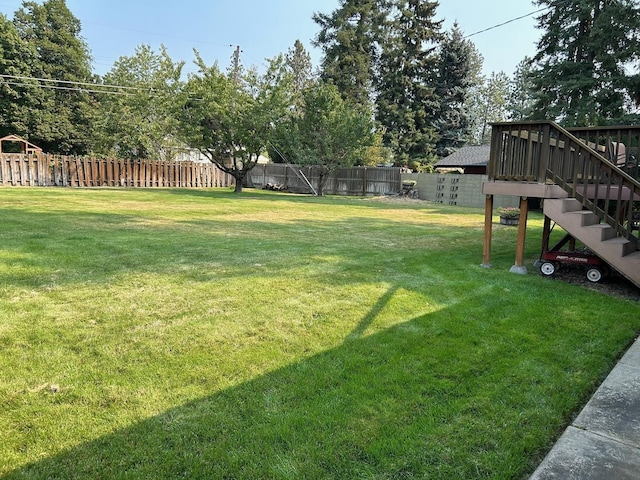 view of yard with a fenced backyard and stairs