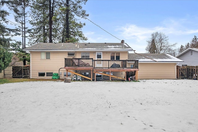 back of property with fence, a chimney, and a wooden deck