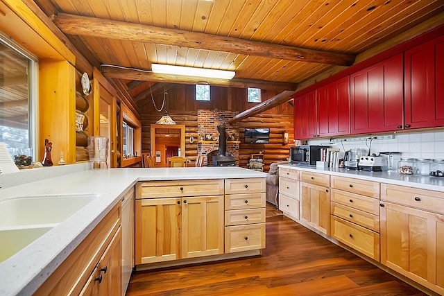 kitchen with lofted ceiling with beams, light countertops, dark wood-type flooring, and rustic walls