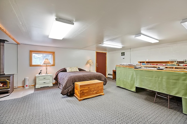 carpeted bedroom with a wood stove and baseboard heating