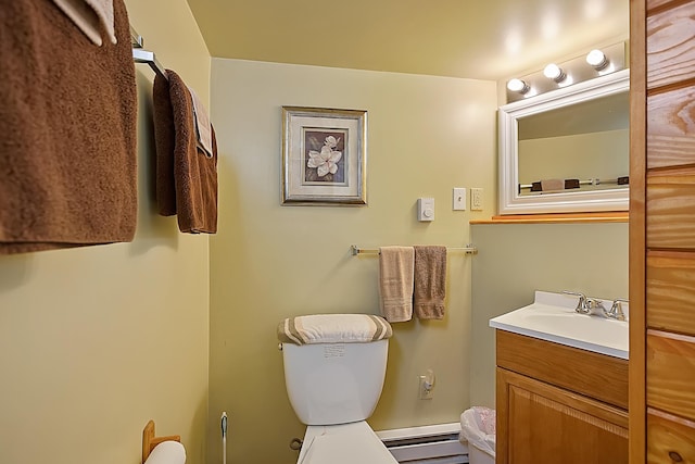 half bath with toilet, a baseboard radiator, and vanity