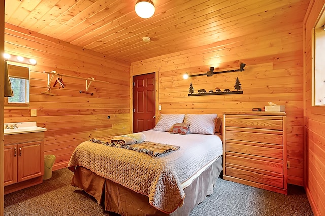 bedroom featuring wooden ceiling, wooden walls, and dark carpet