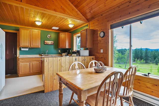 dining room with wood walls, baseboard heating, wooden ceiling, and a mountain view