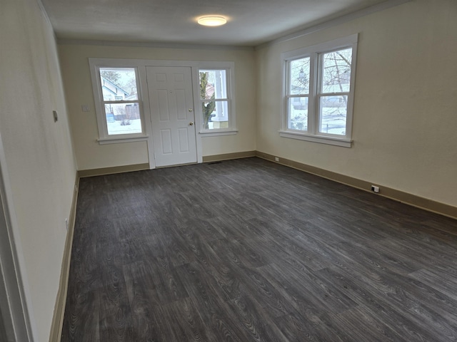 foyer with dark wood finished floors and baseboards