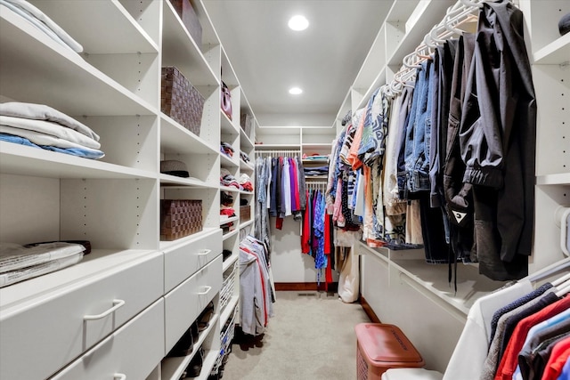 spacious closet featuring light colored carpet