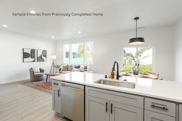 kitchen with a sink, open floor plan, hanging light fixtures, a wealth of natural light, and dishwasher