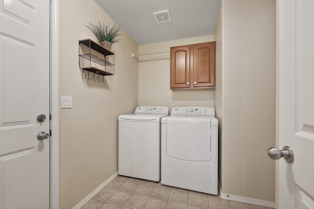 washroom with cabinet space, light tile patterned floors, baseboards, visible vents, and separate washer and dryer