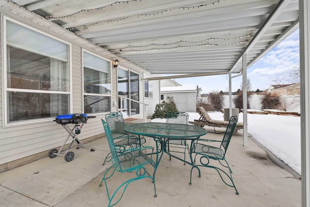 snow covered patio with fence and outdoor dining space