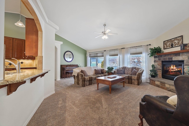 living area featuring high vaulted ceiling, light carpet, a fireplace, and ceiling fan