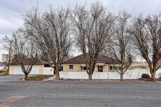 ranch-style house with a garage and a fenced front yard