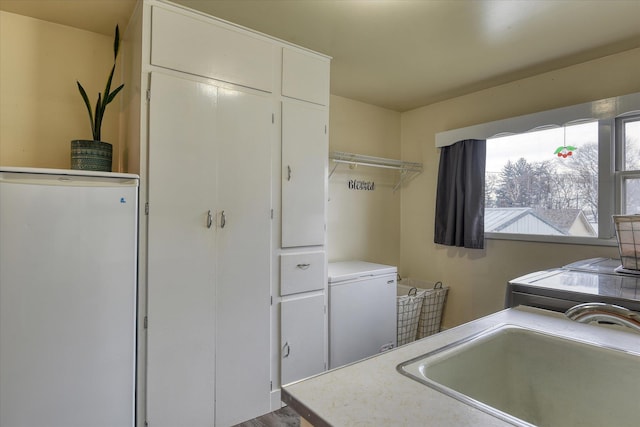 laundry room with cabinet space and a sink