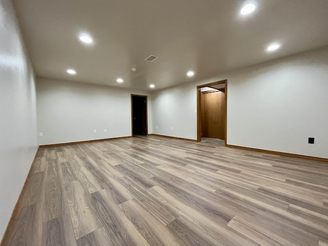 spare room with baseboards, light wood-type flooring, visible vents, and recessed lighting