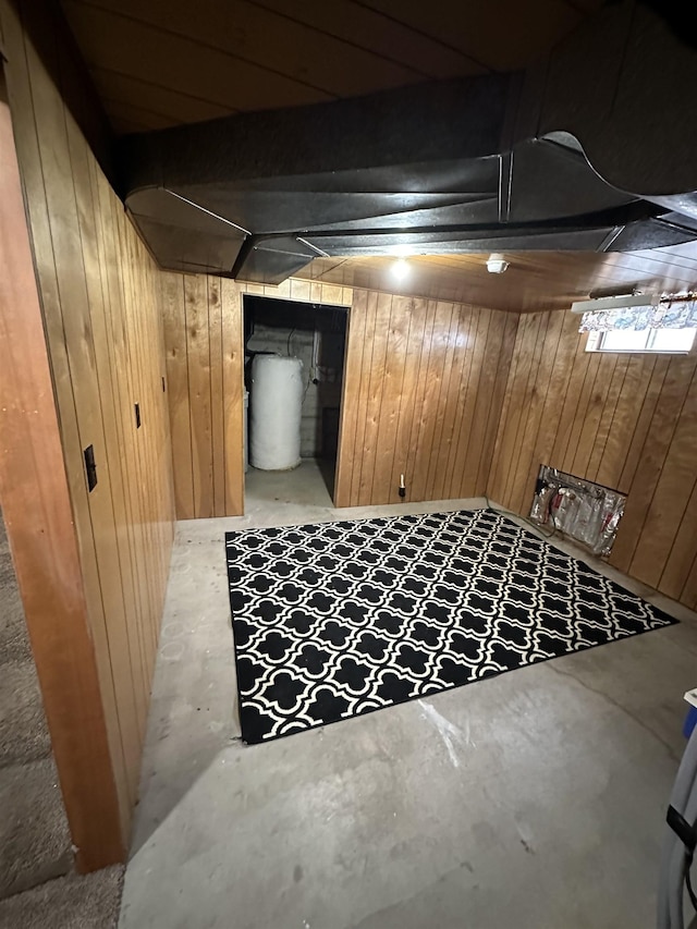 finished basement featuring gas water heater and wooden walls