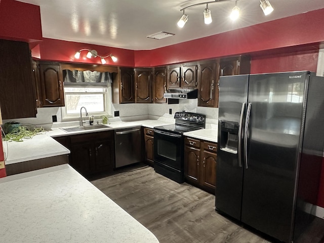 kitchen with light countertops, stainless steel dishwasher, fridge with ice dispenser, under cabinet range hood, and black / electric stove