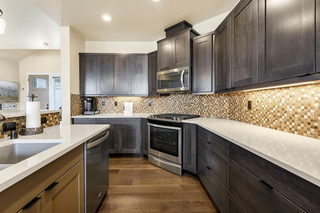 kitchen with dark brown cabinetry, tasteful backsplash, dark wood finished floors, appliances with stainless steel finishes, and light countertops