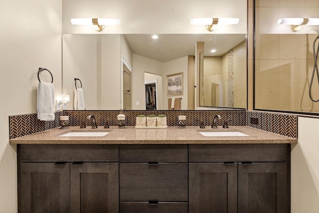 full bath featuring double vanity, a shower stall, and a sink