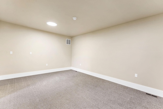 carpeted empty room featuring baseboards and visible vents