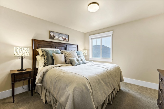 bedroom with dark colored carpet and baseboards