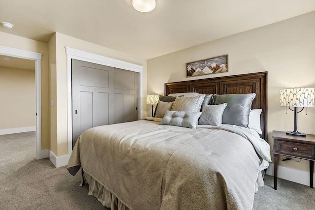 bedroom featuring baseboards, a closet, and light colored carpet