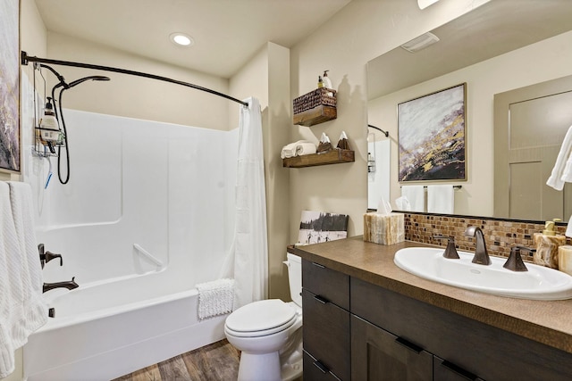 bathroom with toilet, wood finished floors, vanity, backsplash, and shower / bath combination with curtain