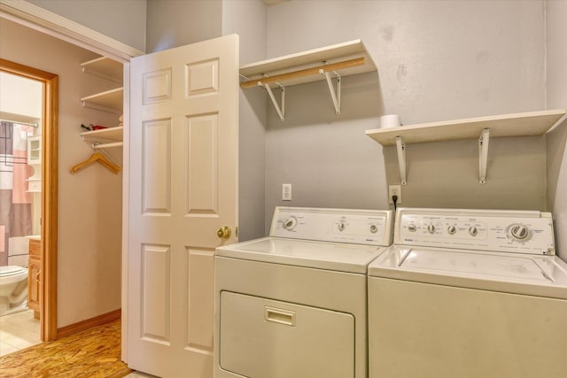 washroom with laundry area, baseboards, and washing machine and clothes dryer