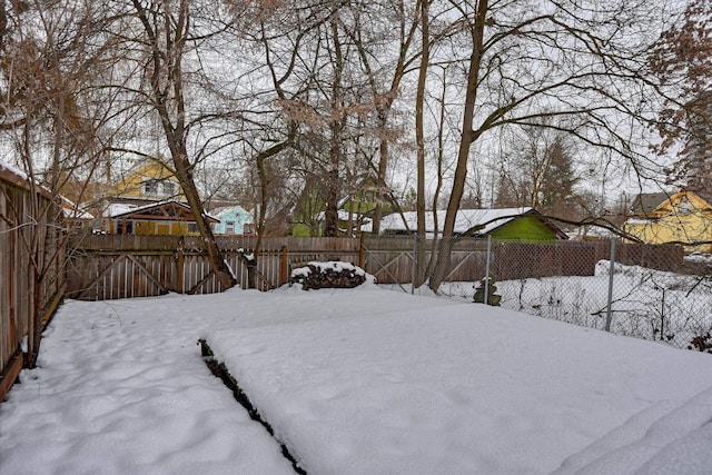 yard covered in snow featuring a fenced backyard