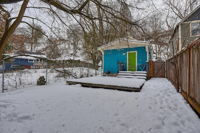 snowy yard with a gate and fence