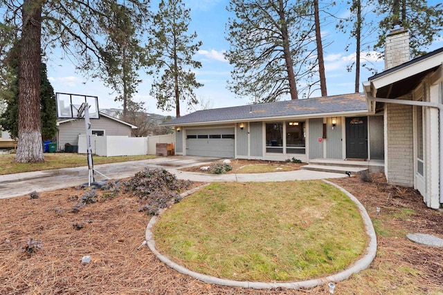 ranch-style home featuring an attached garage, fence, driveway, a front lawn, and a chimney