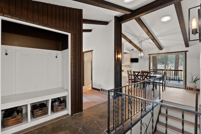 interior space with lofted ceiling with beams, baseboards, visible vents, and a notable chandelier