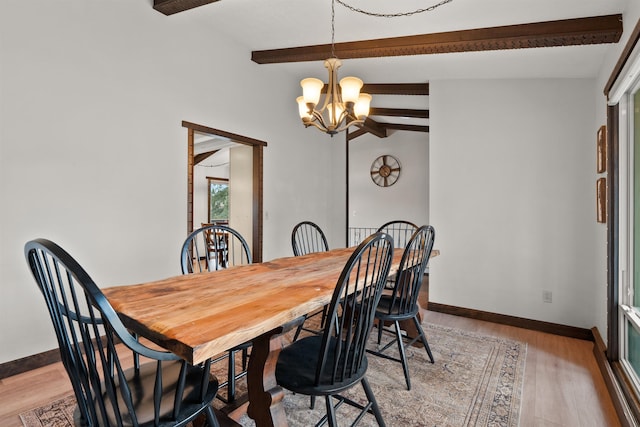 dining space featuring a chandelier, lofted ceiling with beams, light wood-type flooring, and baseboards