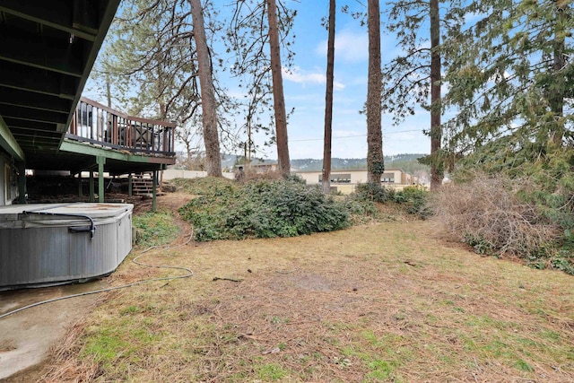 view of yard featuring a deck and a hot tub