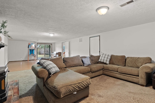 living area featuring visible vents, a textured ceiling, and wood finished floors