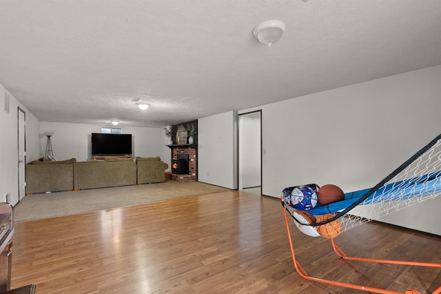 unfurnished living room with a textured ceiling, a fireplace, and light wood-style flooring