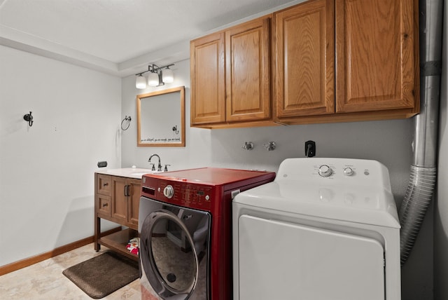 laundry room featuring cabinet space, baseboards, washer and clothes dryer, and a sink