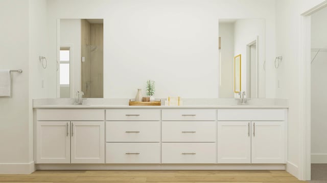 full bath with a stall shower, a sink, and double vanity