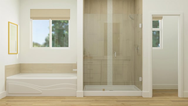 full bathroom featuring a stall shower, a bath, and wood finished floors